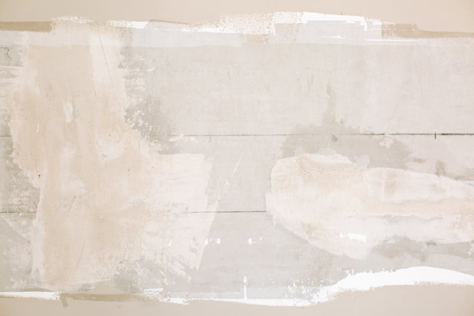 Close-up of an unfinished wall showing plaster and paint textures in a home renovation.